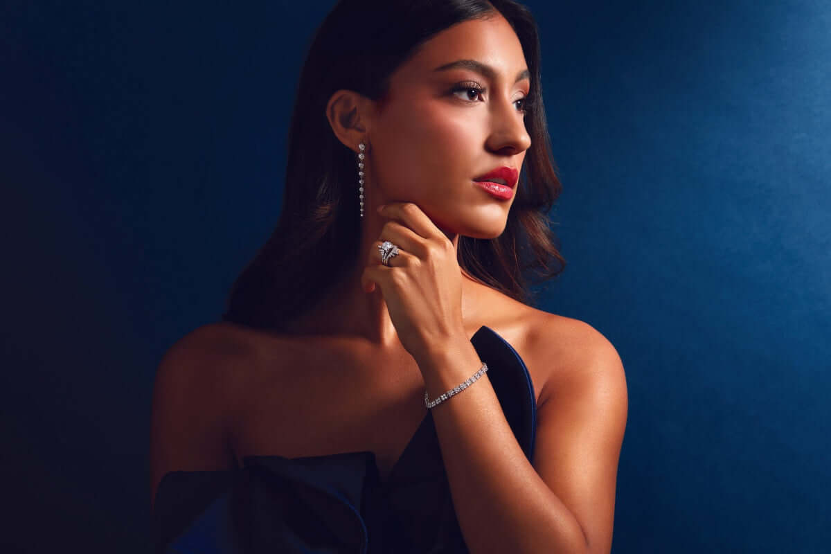 Woman wearing jewelry against a dark blue background farsi jewelers, sandy springs