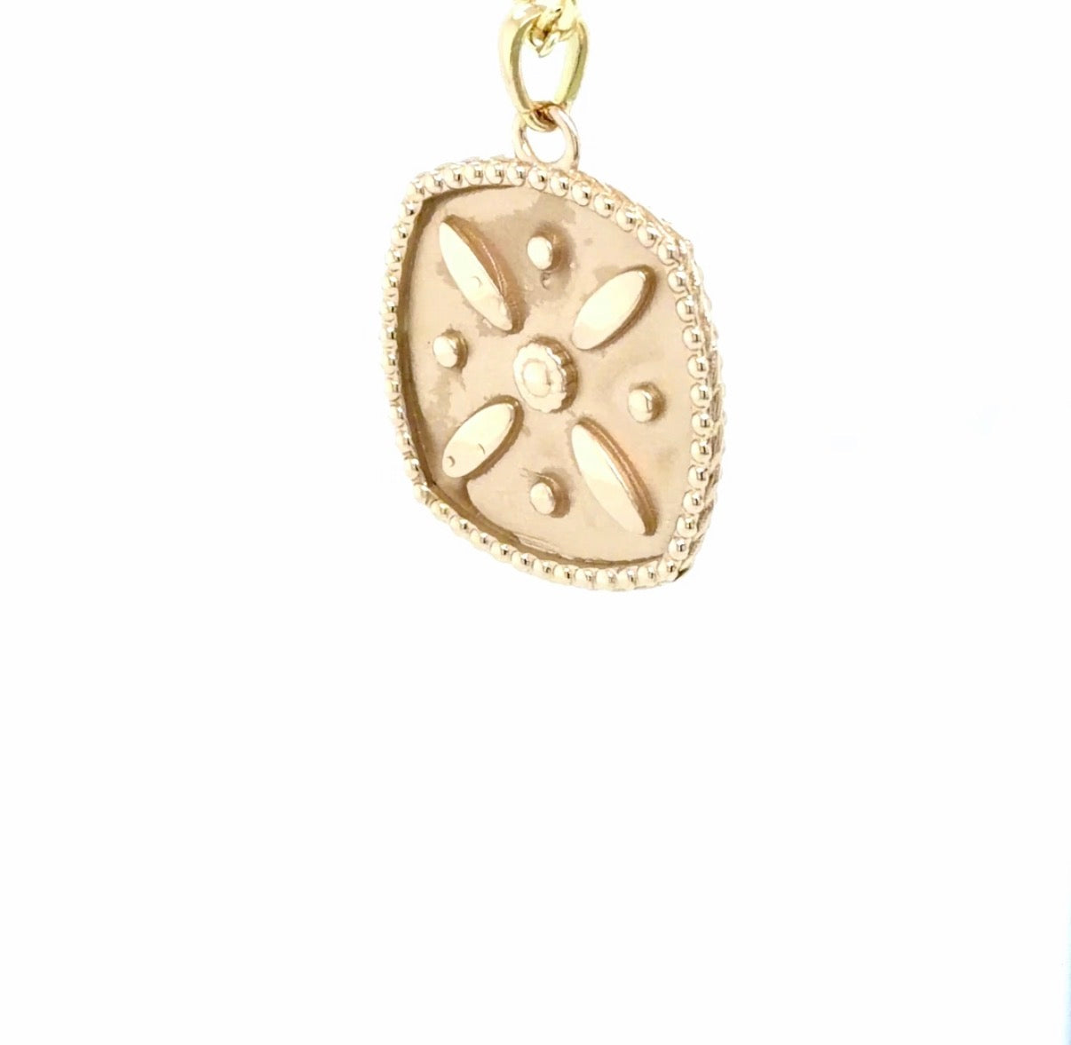 18K yellow gold Derafsh Kaviani pendant, a cushion-square medallion with a milgrain beaded edge and four petals around a beaded star centre, designed and made at Farsi Jewelers