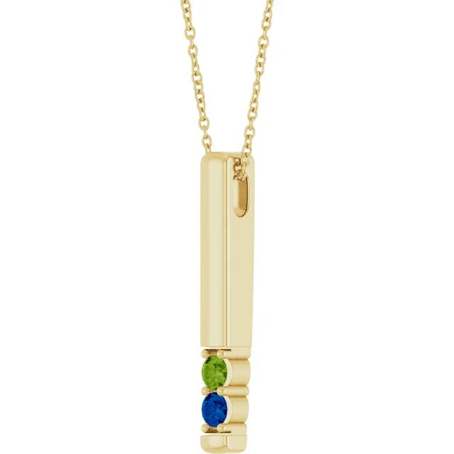 Yellow gold family birthstone bar necklace at an angle, showing the two stones set at the base of the bar