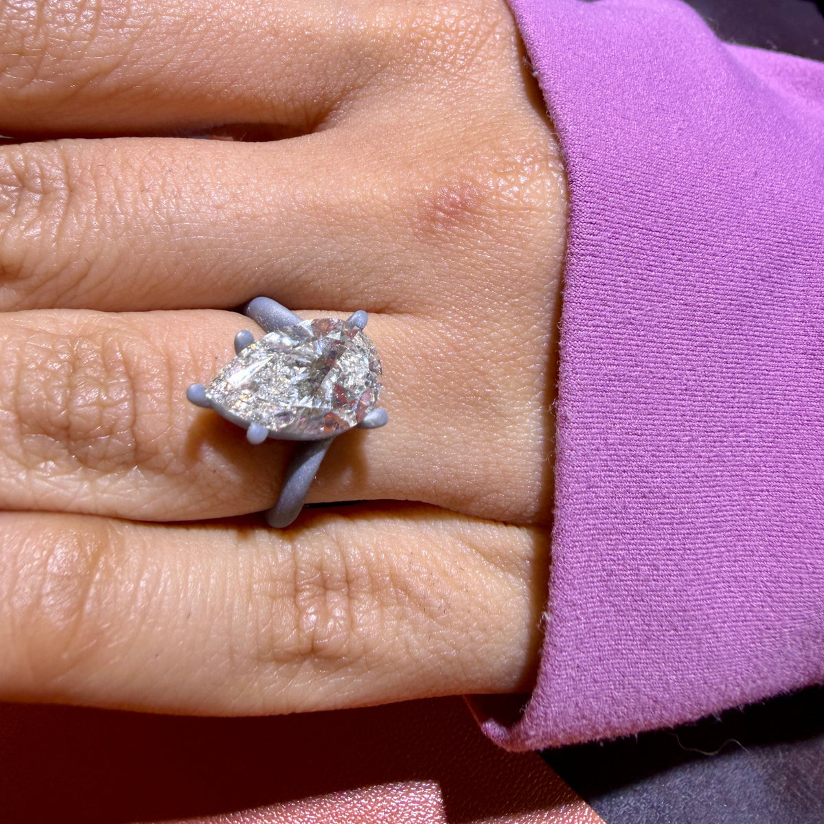 Customer trying on the printed model of the 18K yellow gold pear-cut bypass engagement ring, the stone set for a fit check before casting, Farsi Jewelers