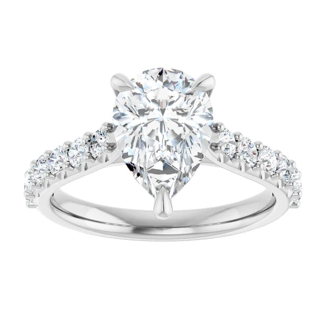 Face-up view of the pear-shape lab-grown diamond, its point held by a single prong and its shoulders by two more, with round accent diamonds tapering down the 14K white gold band