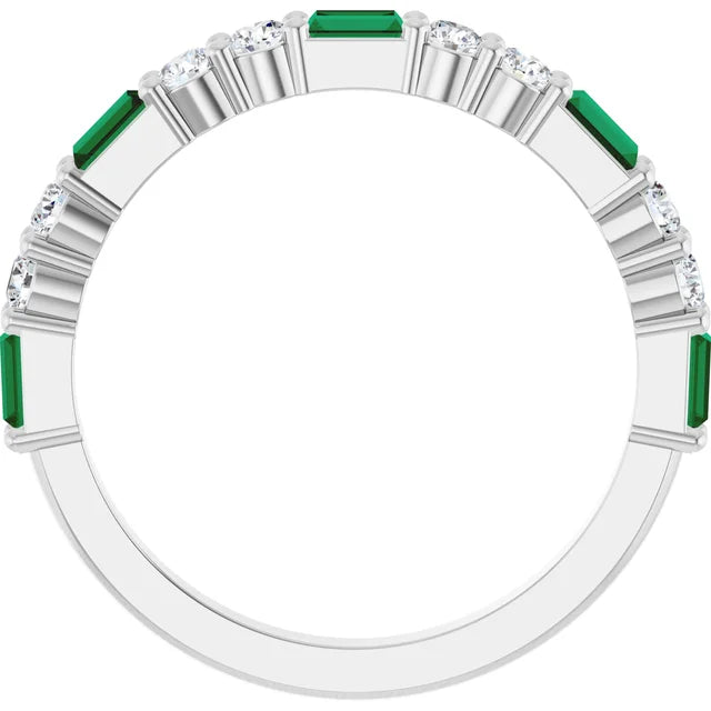 Lab-grown emerald and diamond band seen face-on through the finger opening, showing the half-eternity layout