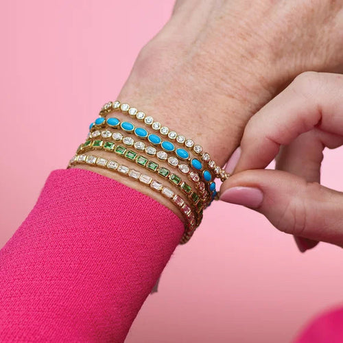Load image 1 in gallery view. Yellow gold bezel-set tennis bracelet on the wrist, styled in a stack with gemstone bracelets