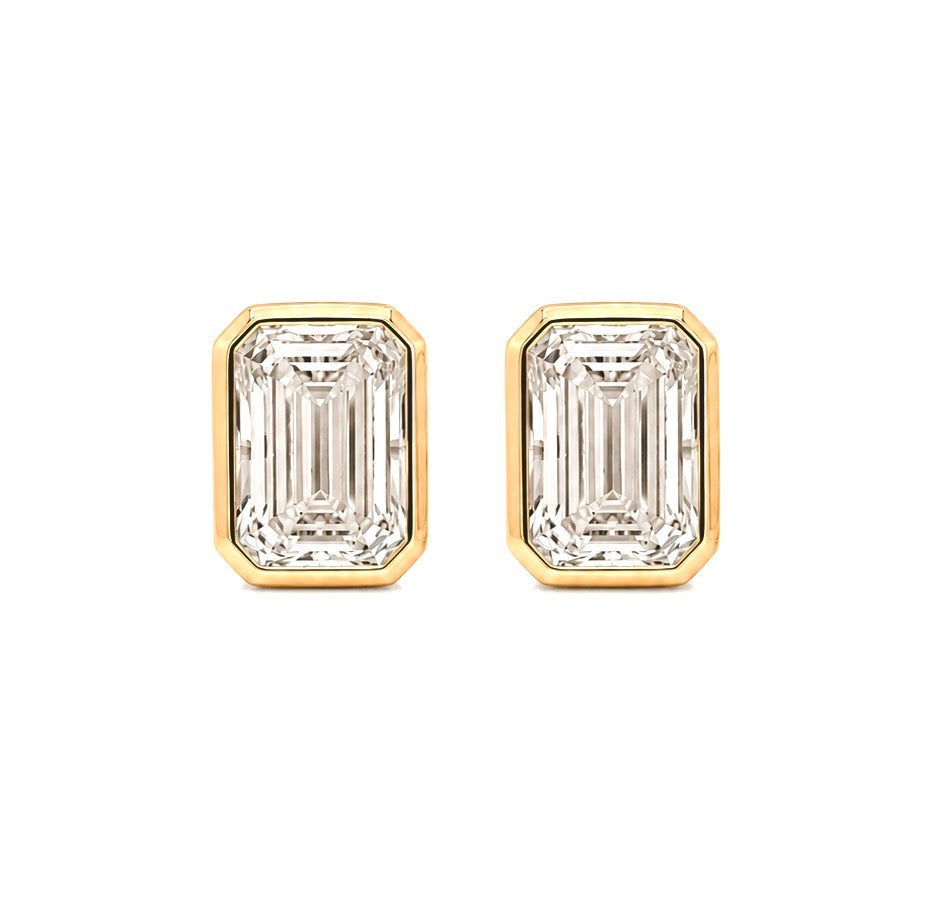 Pair of emerald-cut lab-grown diamond stud earrings in 14K yellow gold, shown face on, each step-cut stone framed in a smooth full bezel
