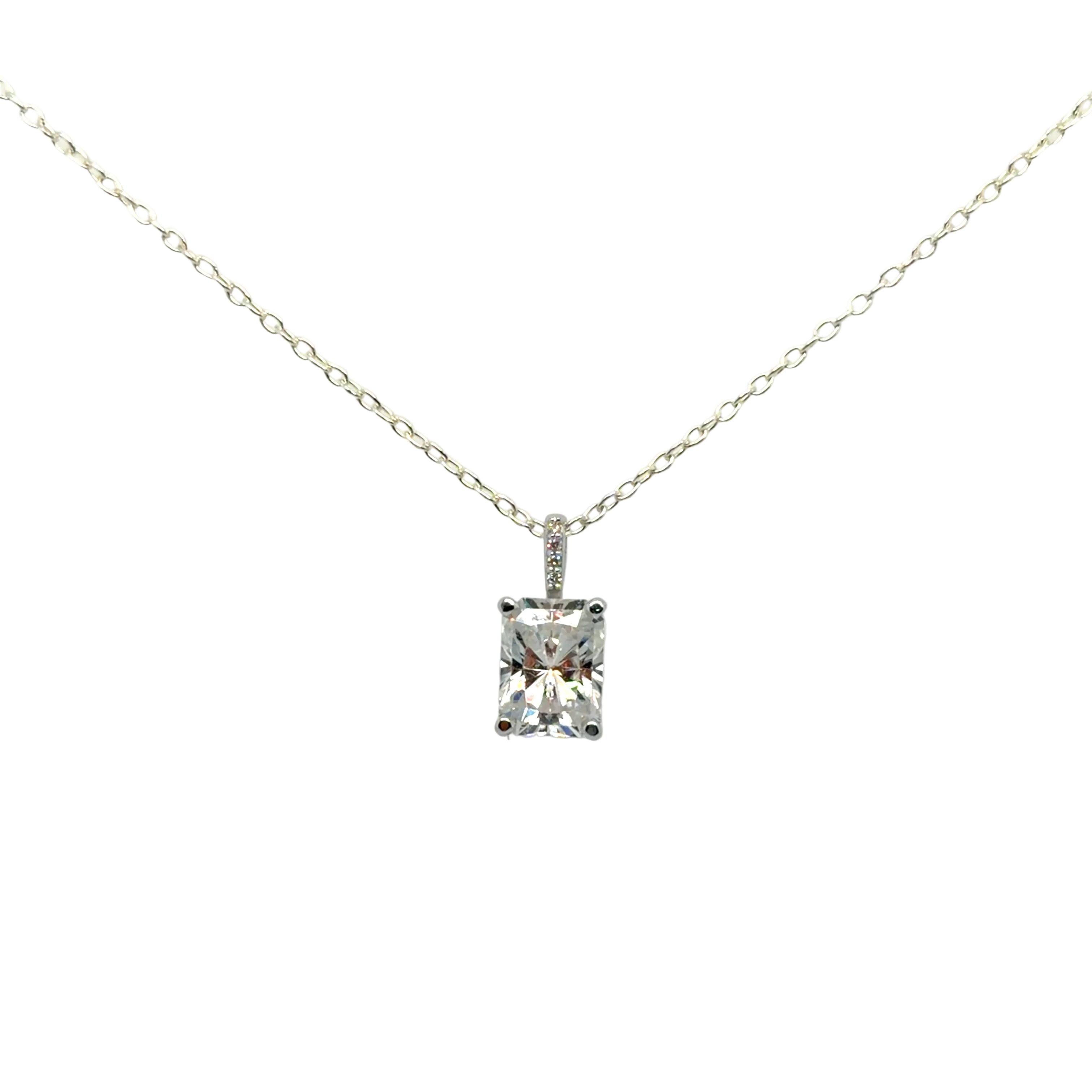 Front view of the 14K white gold solitaire pendant mounting with a radiant-cut moissanite and a diamond-set bail, hanging from a display chain. Chain and center stone are not included.