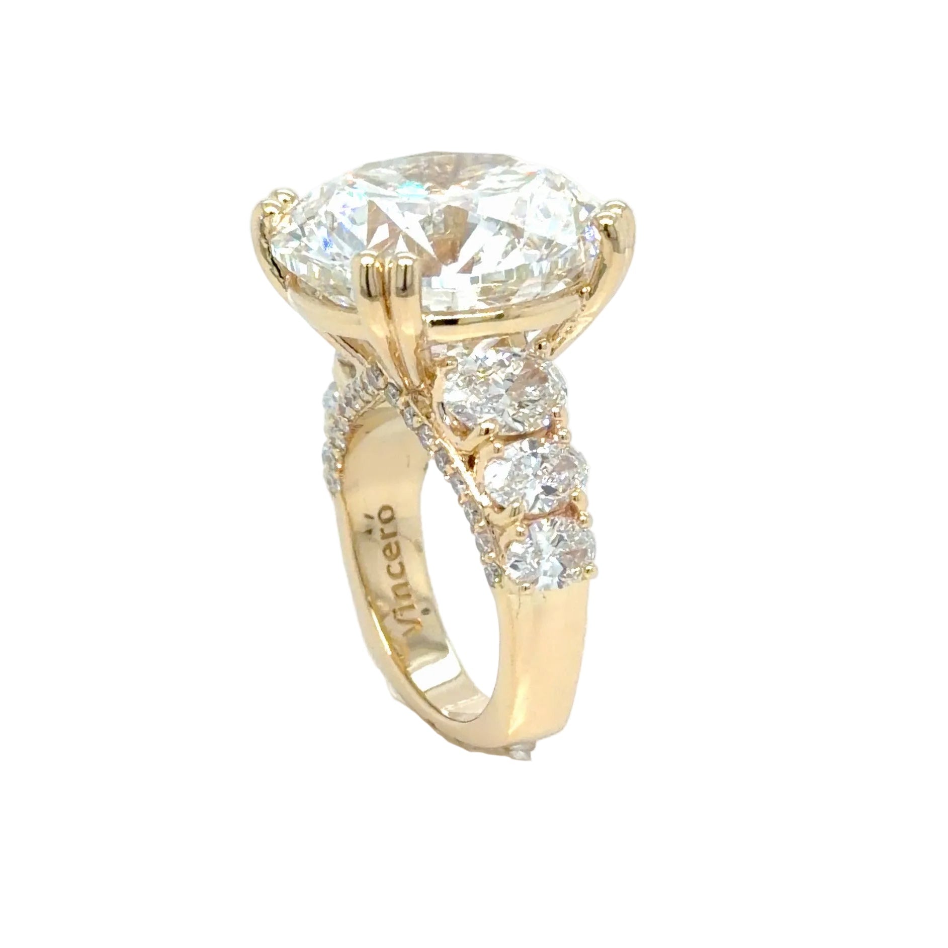 Side profile of the 14K yellow gold ring, the round diamond raised on a split-shoulder head above three graduated oval diamonds running down the shank