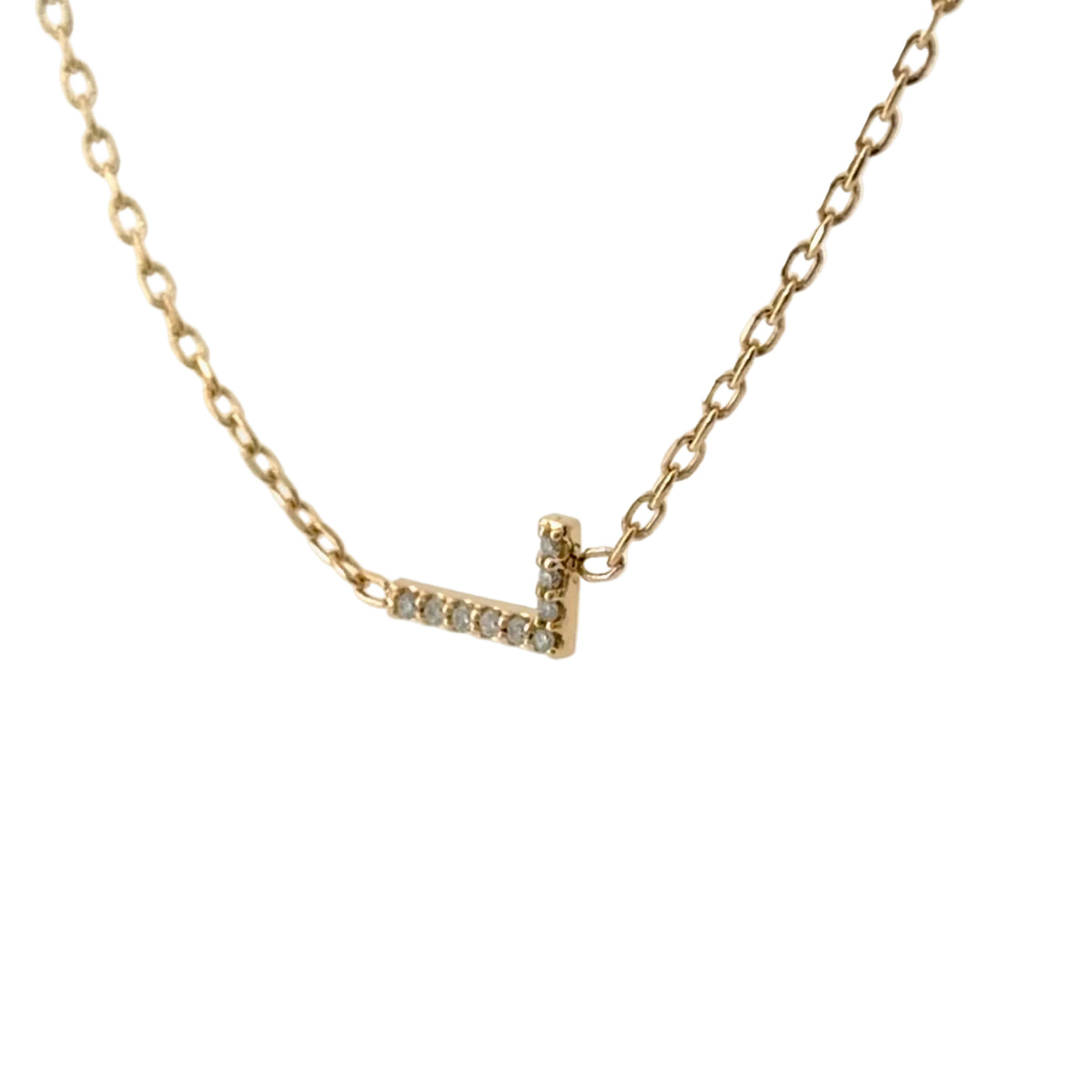 Angled view of the diamond initial L, with the chain attached at each end of the letter so it lies flat