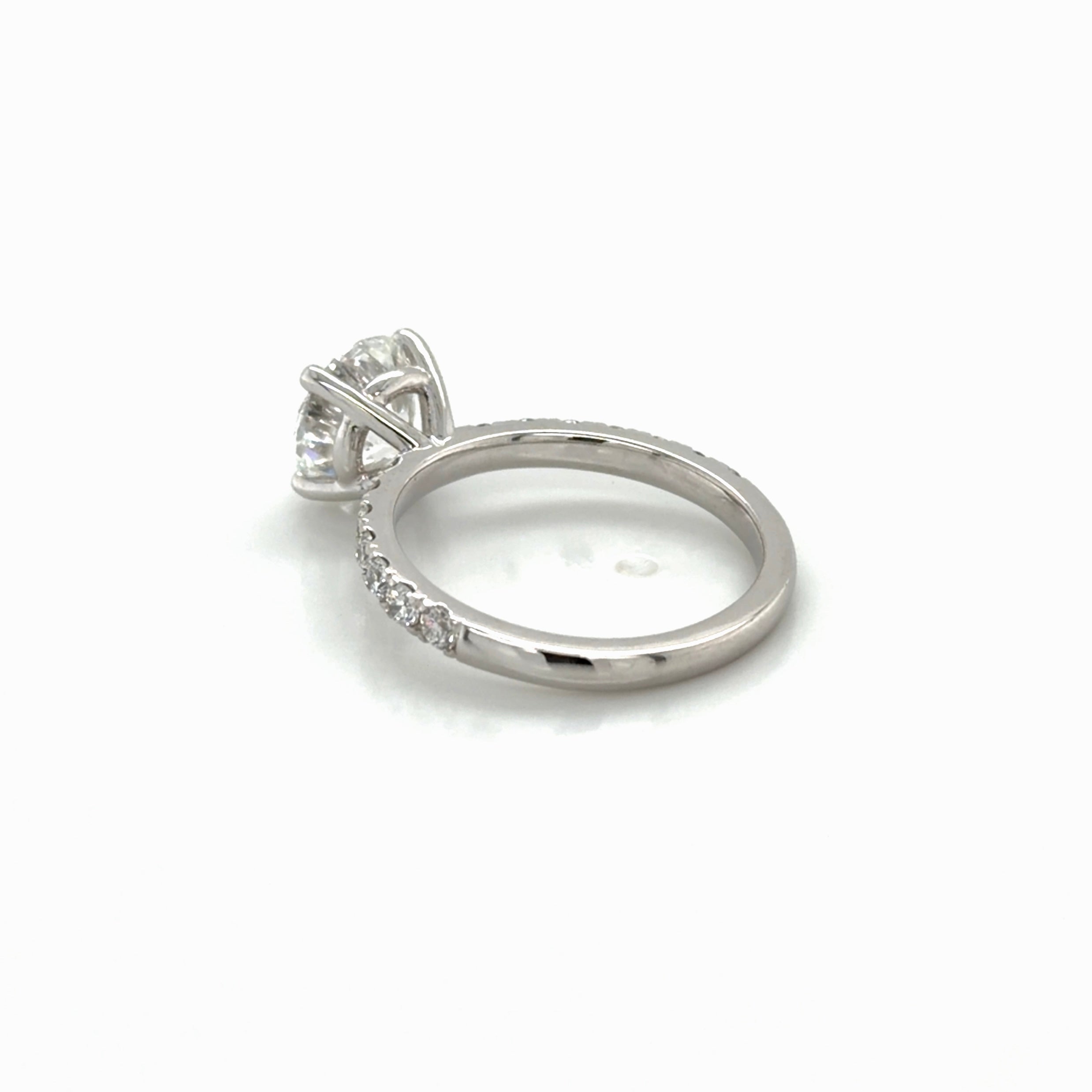 Angled view of the rebuilt 14K white gold four-prong solitaire engagement ring with French-set pavé, Farsi Jewelers