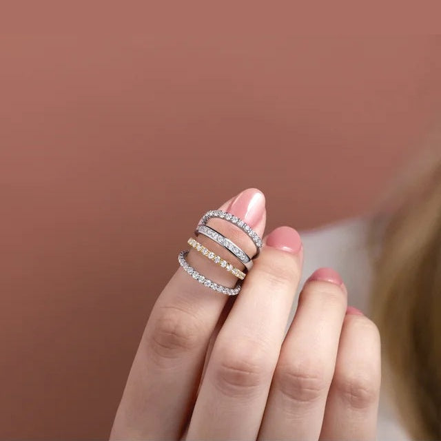 Model wearing a stack of round diamond bands in white and yellow gold from the Ever & Ever line; the yellow band is the 2 mm, half-carat sister of this 0.75 carat French-set style