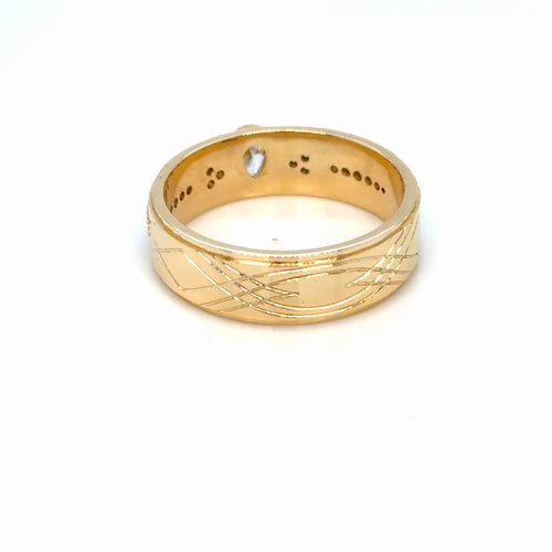 Load image 1 in gallery view. Men's 18K yellow gold wedding band tilted to show the inside of the band, the engraved crossover lattice and the pear-cut lab-grown diamond