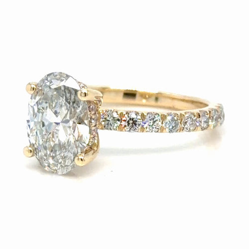 Load image 1 in gallery view. 14K yellow gold engagement ring with an oval lab-grown diamond held in four prongs, a hidden halo tucked beneath the center stone, and French set round diamonds along the band