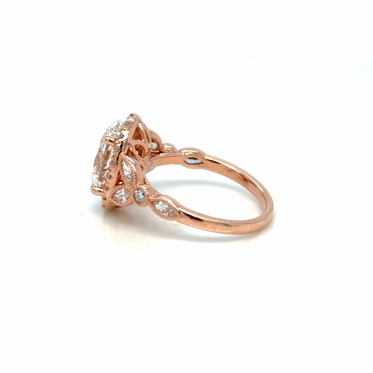 Side view of the 14K rose gold oval lab-grown diamond halo engagement ring showing the milgrain-edged bezel accents and pierced gallery, Farsi Jewelers