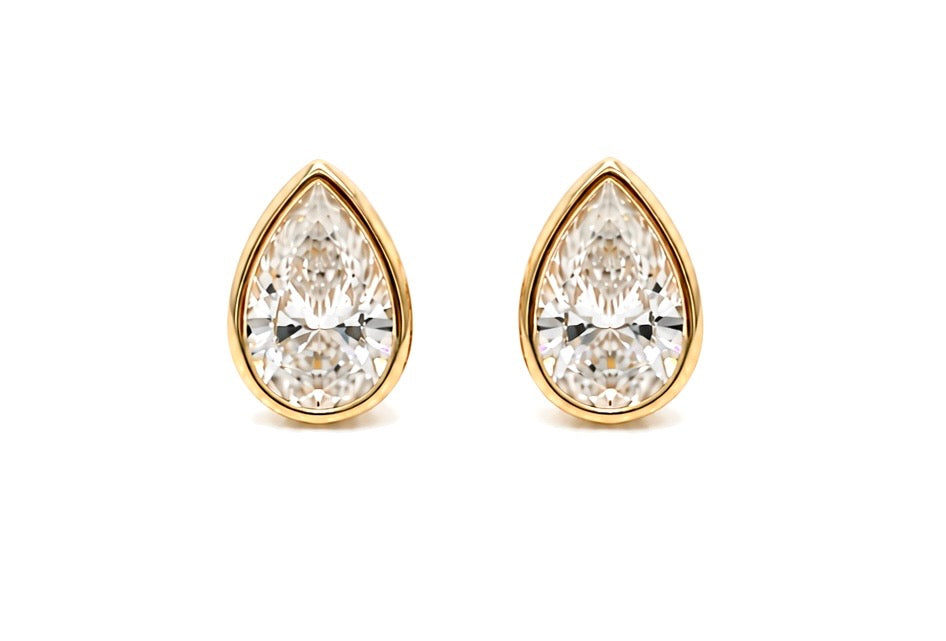 Pair of pear-shape lab-grown diamond stud earrings in 14K yellow gold, each stone held in a full bezel, shown face on