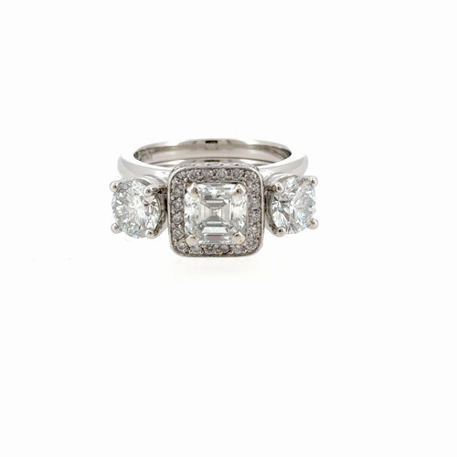 Load image 1 in gallery view. Platinum wrap-style ring enhancer worn with an engagement ring, its two round diamonds sitting on either side of the ring's center stone, front view