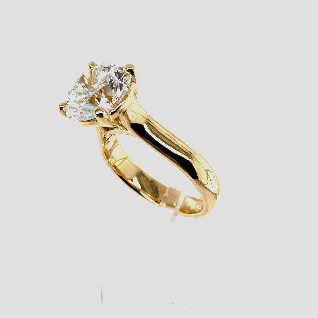 Rotating video of a custom 14K yellow gold cathedral solitaire ring with a 5-carat natural round brilliant diamond — Farsi Jewelers