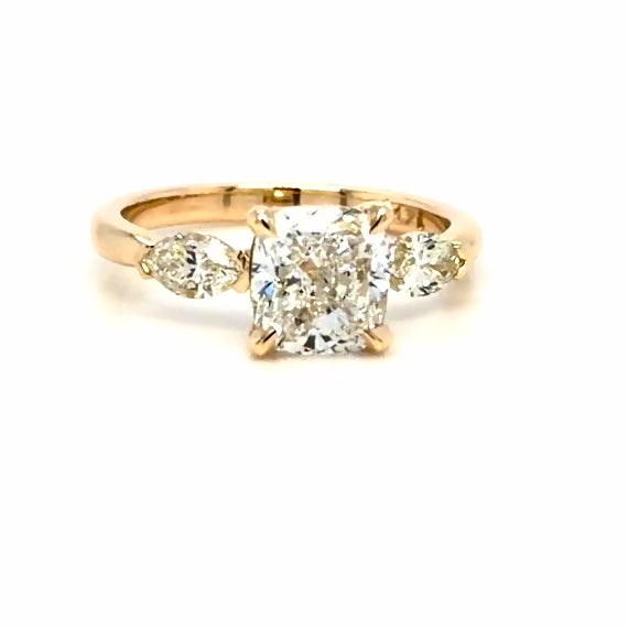 3 stone costume engagement ring in 14K yellow gold and a cushion-cut center diamond 