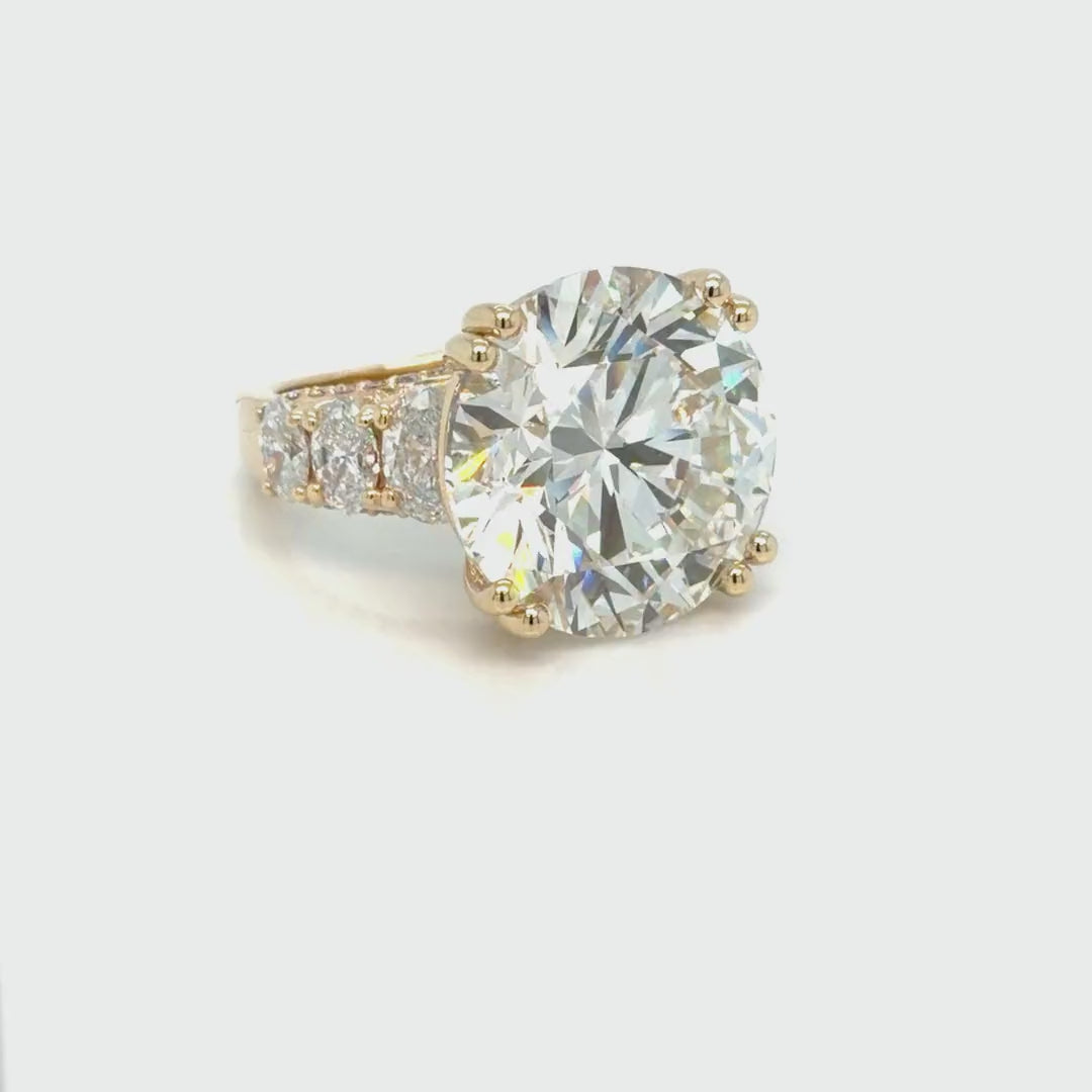 Rotating 360-degree view of the 14K yellow gold ring, turning to show the 24.01 carat round lab-grown diamond, the graduated oval side stones and the pave-set band from every angle
