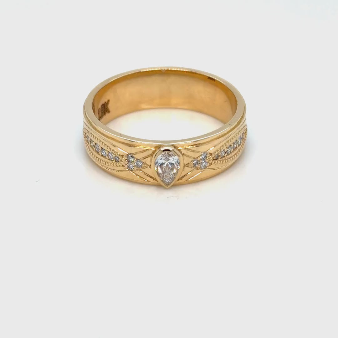 Video of the 18K yellow gold 7 mm men's wedding band turning, showing the pear-cut lab-grown diamond and the engraved crossover lattice