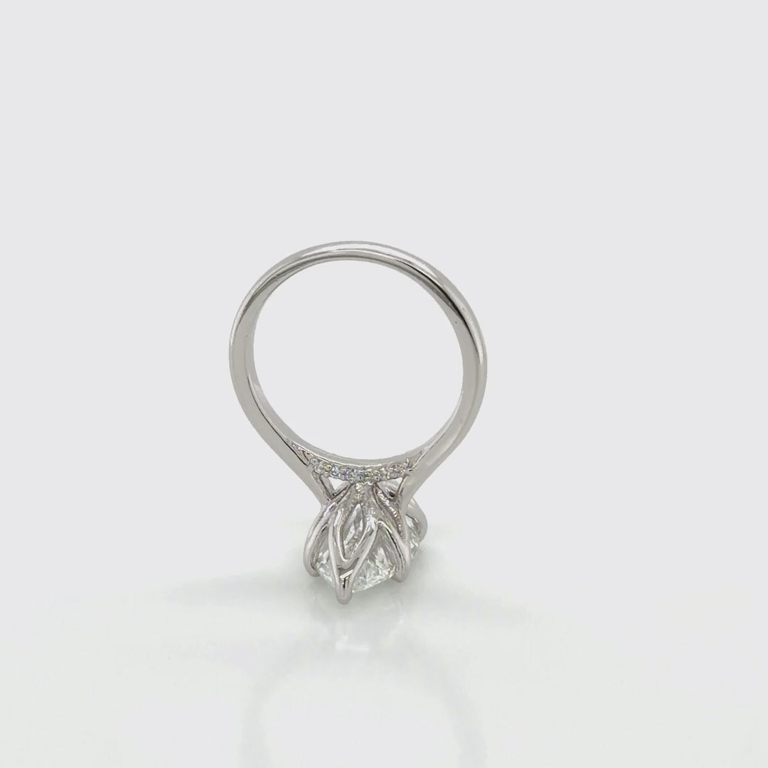 Rotating view of a platinum marquise solitaire engagement ring mounting with tulip prongs and a pavé undergallery, shown with a marquise-shape center stone, at Farsi Jewelers
