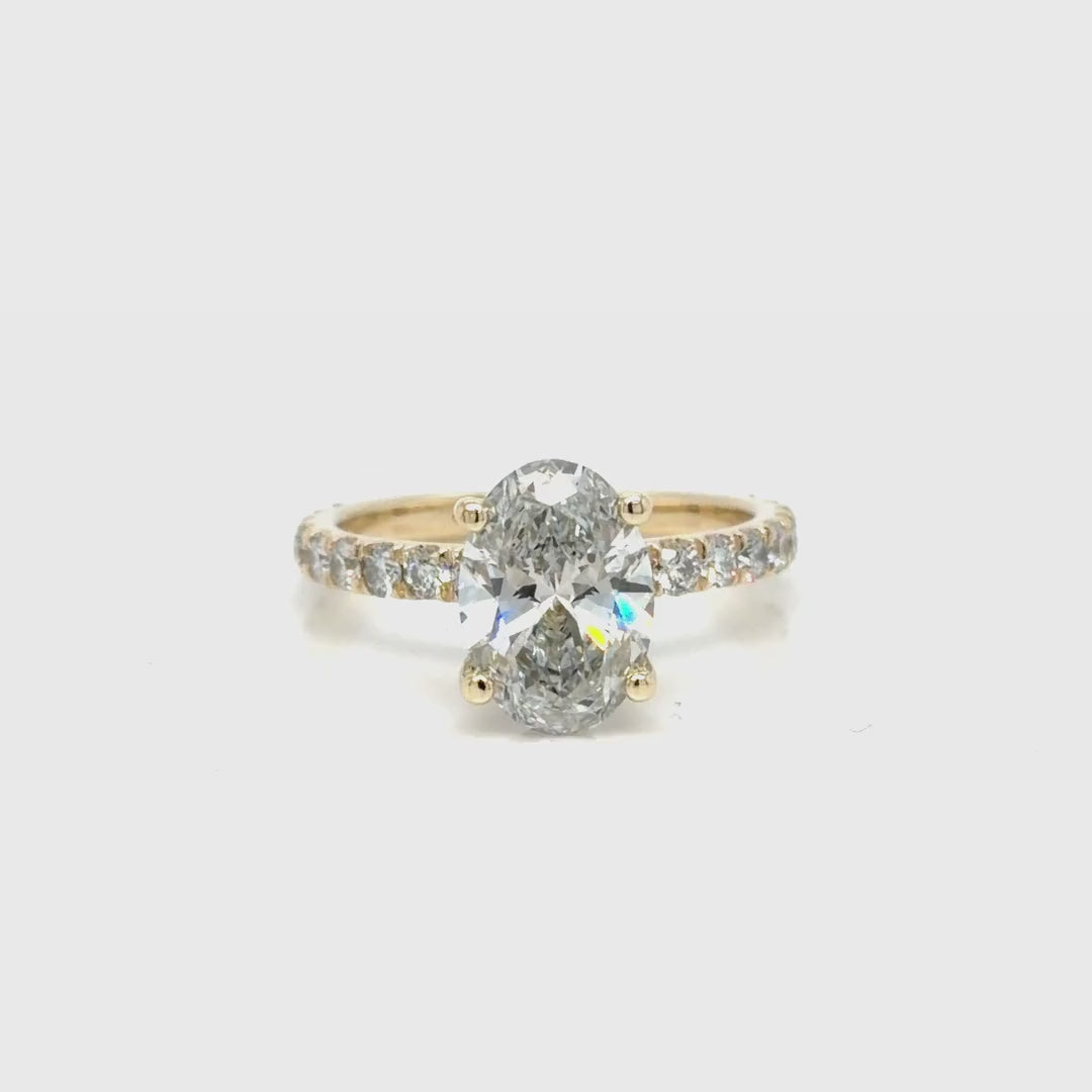 Rotating view of the 14K yellow gold oval lab-grown diamond engagement ring, showing the hidden halo beneath the center stone and the French set diamond band