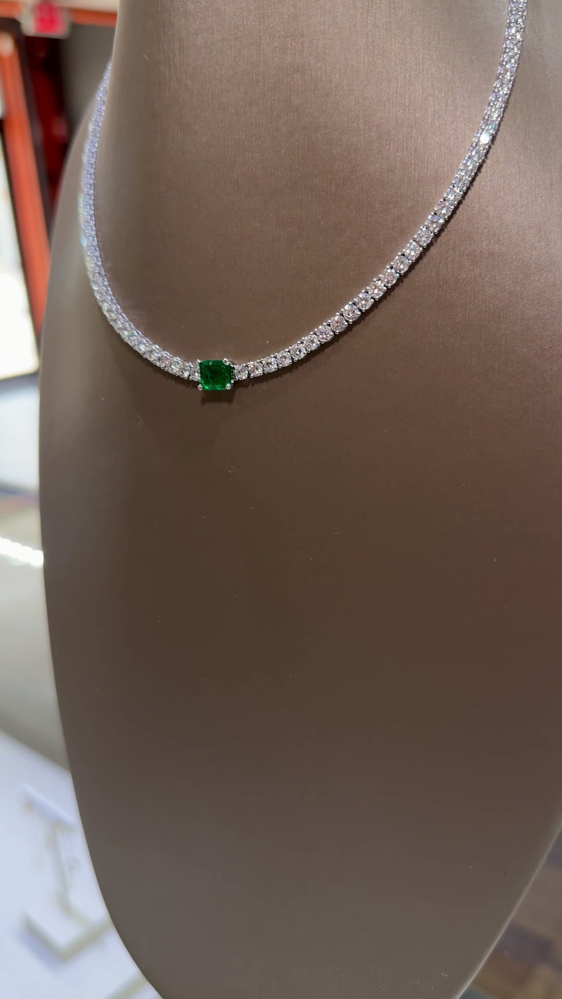 14k white gold diamond tennis necklace with green emerald center stone. farsi jewelers sandy springs