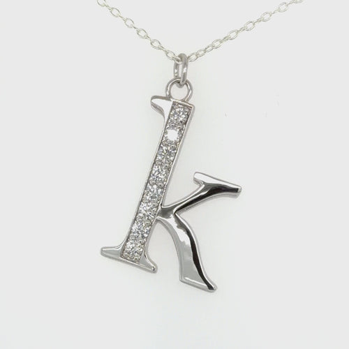 Load image 1 in gallery view. Rotating video of a custom 14K white gold pavé diamond ‘K’ initial pendant by Farsi Jewelers
