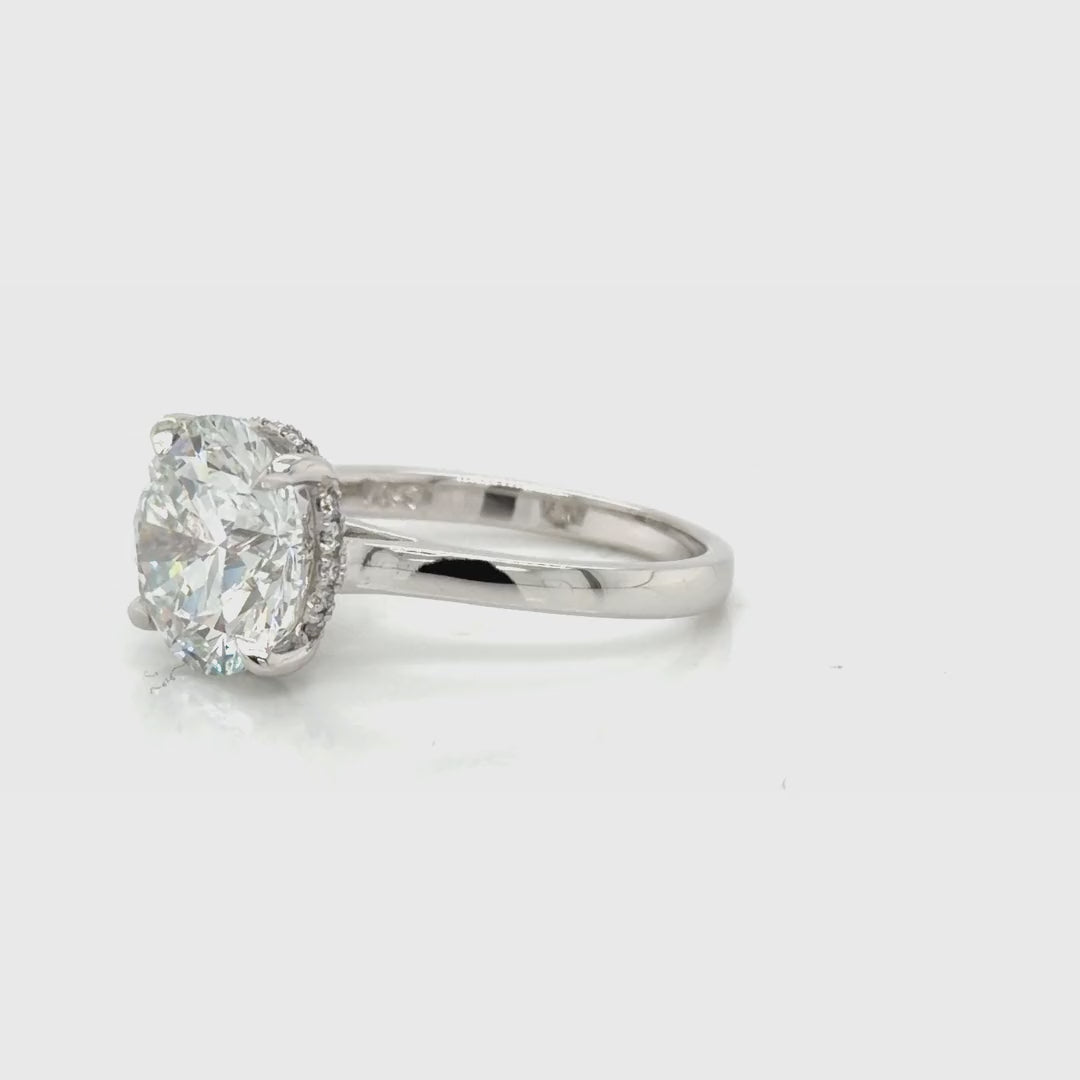 Rotating video of the 14K white gold 4 CT round hidden halo cathedral engagement ring, turning to show the hidden halo beneath the center stone