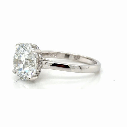 Load image 1 in gallery view. Side profile of the hidden halo ring, the round diamond seen from the edge with the concealed halo visible beneath it and the cathedral shoulders rising to the setting